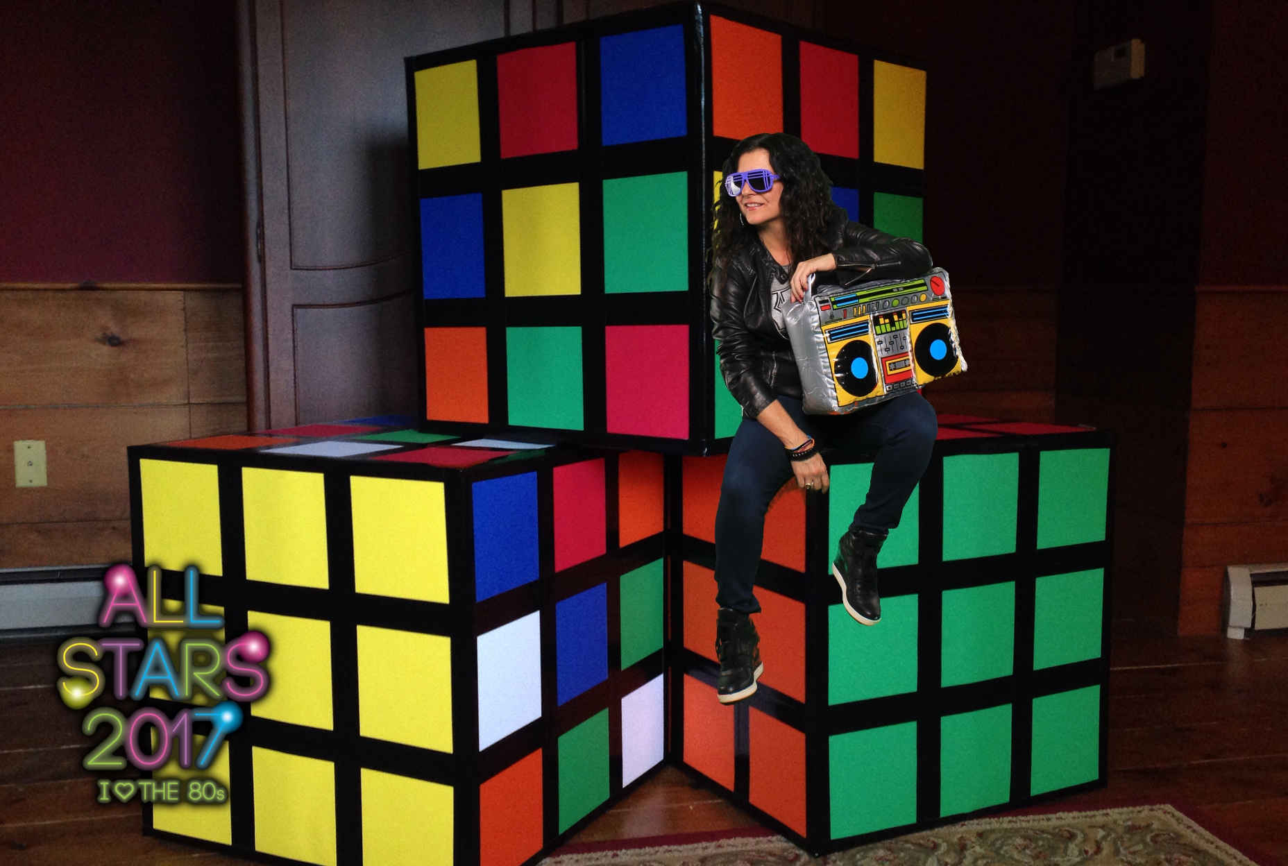 80's theme - Lady sitting on a Rubik's cube.